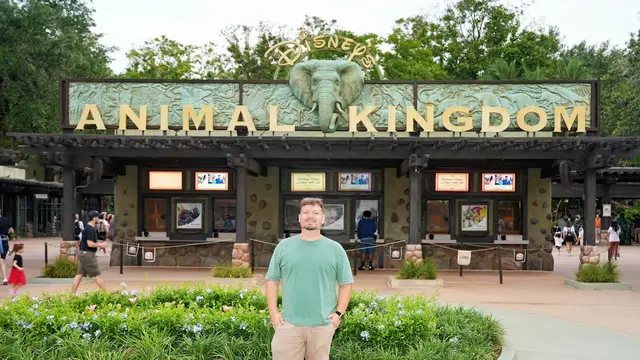 Thomaz em frente ao letreiro e às bilheterias da entrada do Animal Kingdom, parque da Disney em Orlando