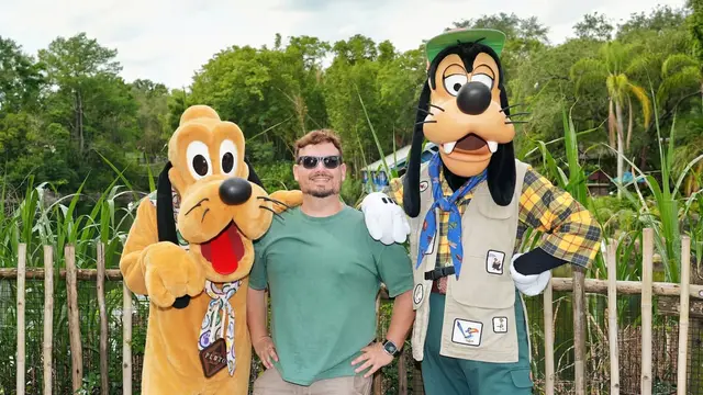 Thomaz com Pluto e Pateta em trajes de safári num encontro com personagens no Animal Kingdom, em Orlando