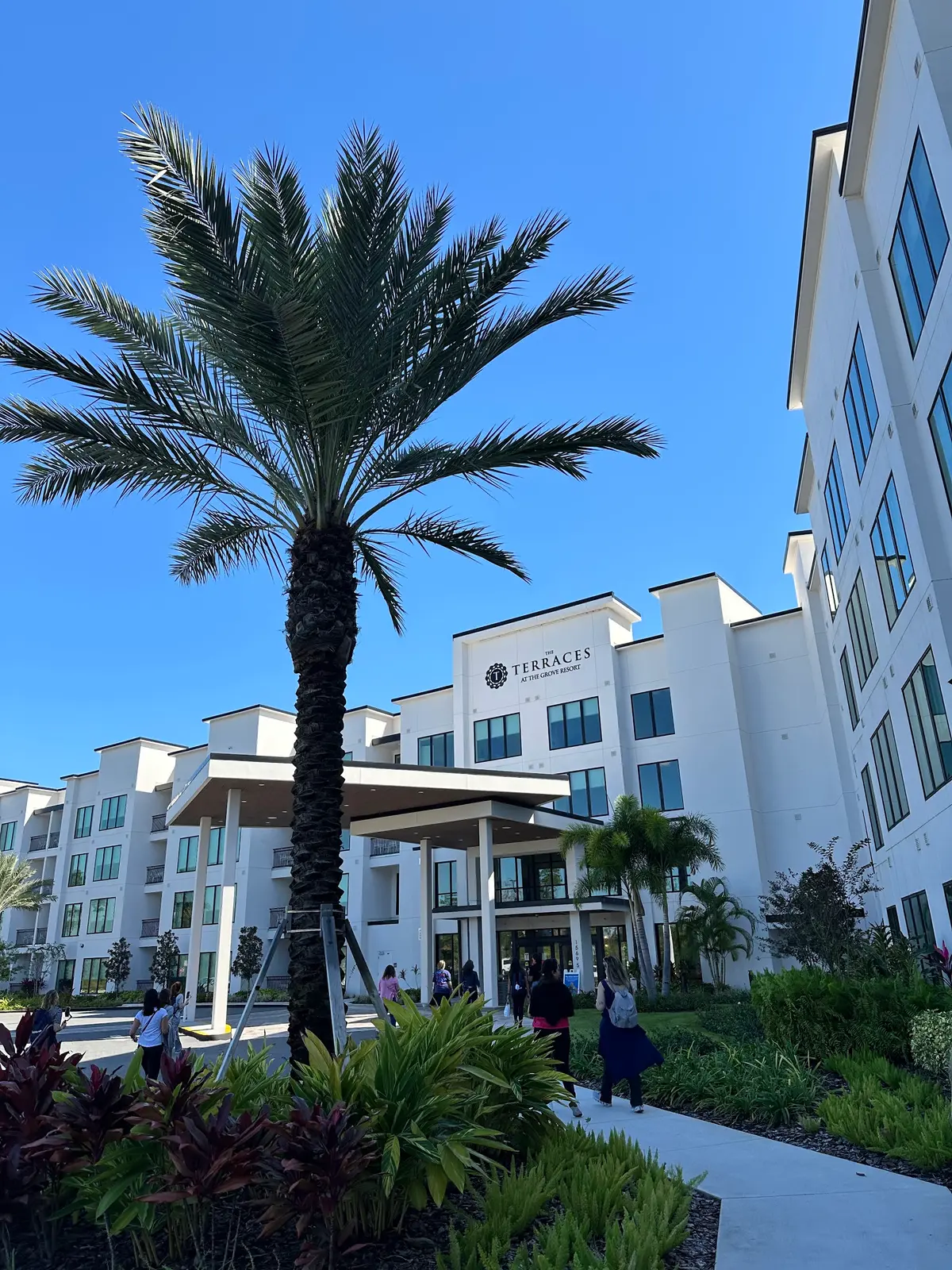 Prédio de resort na região de Orlando, com palmeira e jardim tropical sob céu azul