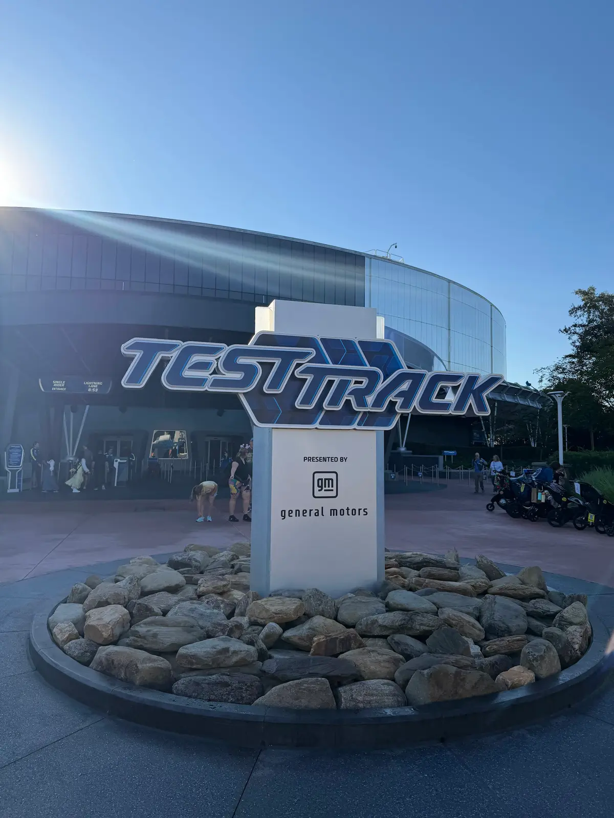 Letreiro da atração Test Track diante do pavilhão, em dia de céu azul no EPCOT