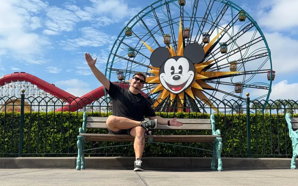 Thomaz, da Desenrola Turismo, sentado em frente à roda-gigante da Disney na Califórnia